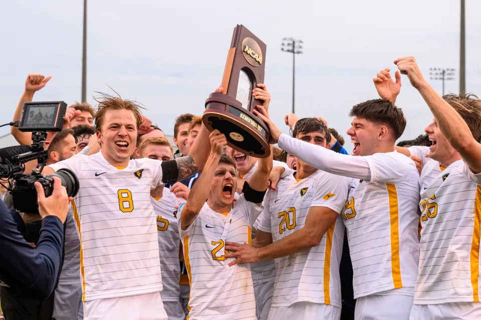 The West Virginia Mountaineers men's soccer team lifts their Semifinalist trophy after clinching the program's first-ever trip to the College Cup.