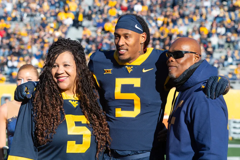 Lance Dixon poses in the Mountaineers blue jersey with family members on his sides during senior recognition. 
