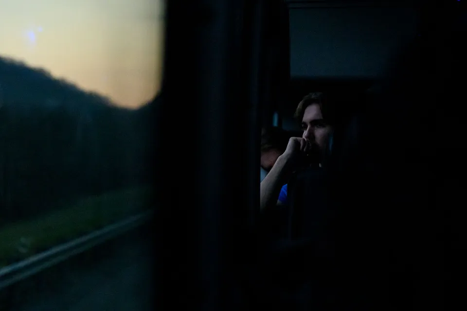 student on the bus looking at sunrise