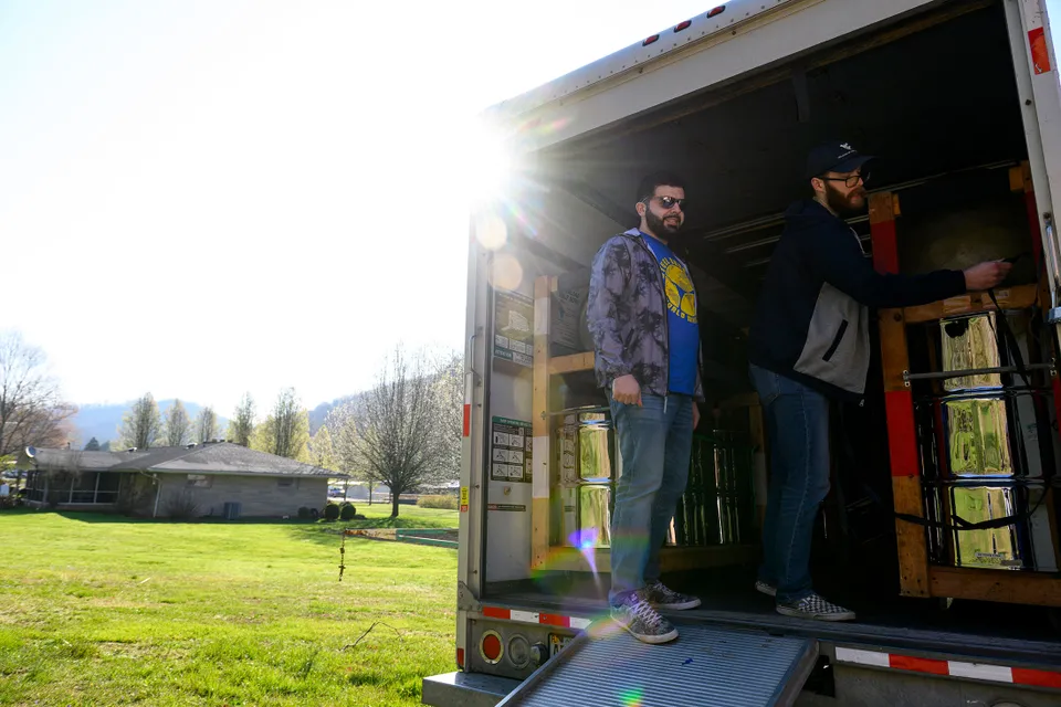 two men unload the trailer