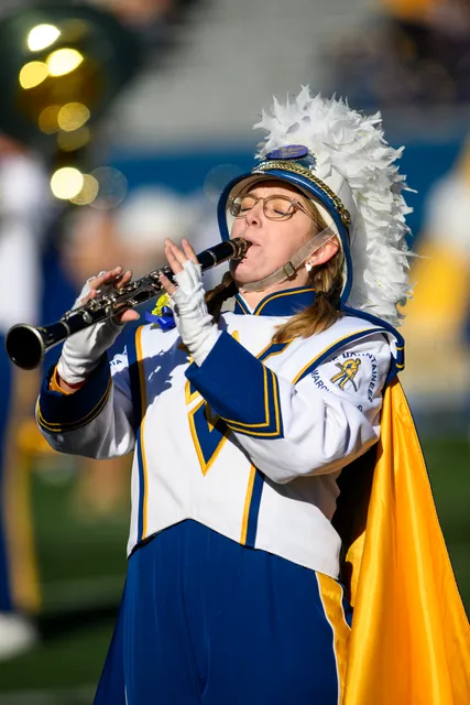 A senior band member plays the clarinet on Mountaineer Field.