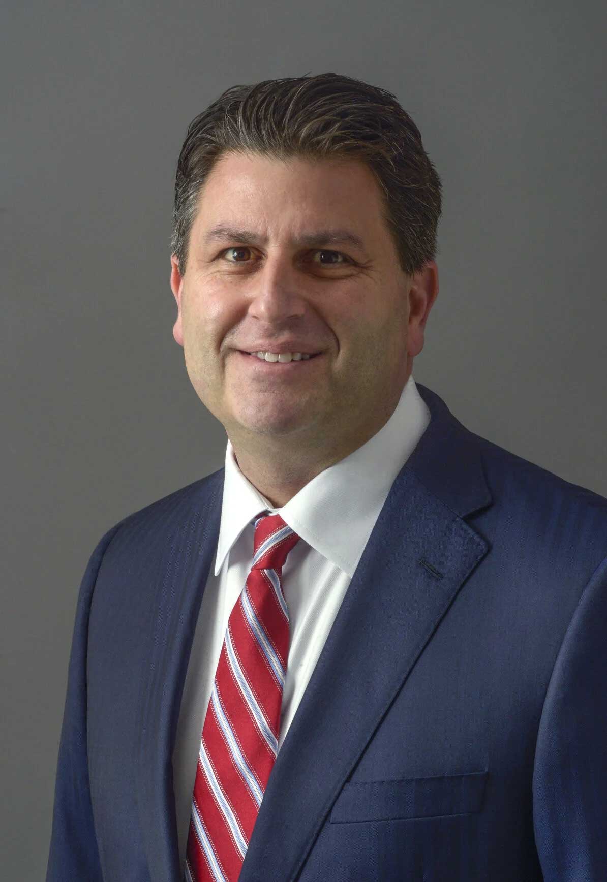 smiling person in suit, striped tie